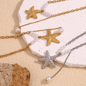Detailed view of starfish pendants with pearls on gold and silver plated necklaces