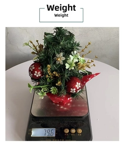 Close-up of a mini Christmas pine tree with red glitter balls and floral cloth base weight