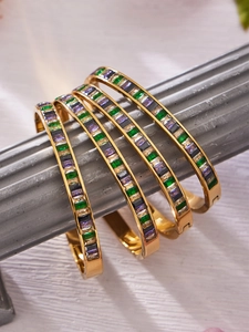 Macro view of gold-plated bracelets featuring baguette-cut multicolored zircon stones