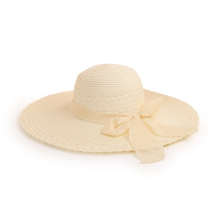 Detail of beige woven straw hat with wide brim and light ribbon bow for sun protection