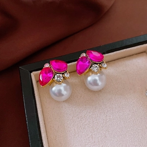 Detail of vintage rose red gem earrings with crystal accents and white pearls