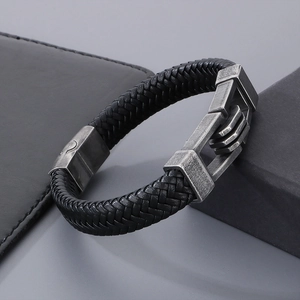 Detail of woven black leather strap and vintage silver metal clasp on men's bracelet