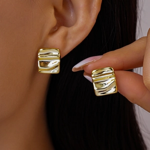 Detailed view of gold rectangular ripple earrings with elegant textured metallic finish