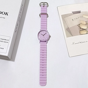 Close-up of lavender quartz watch with wavy silicone strap and minimalist dial display