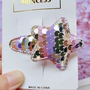Detail of star-shaped hair clip with shimmering purple and silver reversible sequins