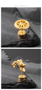 Macro detail of gold-plated ram head and gear studs on dark rock background