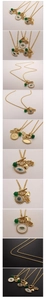Detail of gold chain necklace with evil eye, hamsa hand, heart charms and green bead