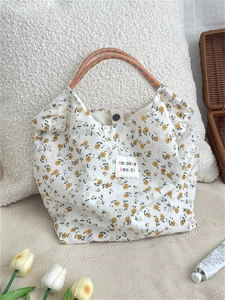 Floral canvas tote bag with woven rope handles and vibrant yellow flower patterns