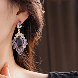 Détail de boucles d'oreilles de luxe avec cristaux violets et pierres marquise
