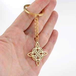 Gold Celtic knot keychain with stainless steel chain shown on a hand palm closeup