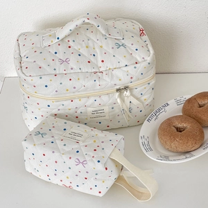 Detailed view of white quilted cosmetic bags with colorful polka dots and bows two-piece set
