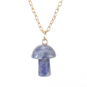 Detail of a natural blue spotted stone mushroom pendant on a delicate gold metal chain