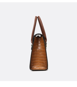 Side view detail of the brown crocodile texture leather handbag showing thickness and structure