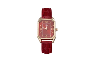 Detail view of octagon gold watch case with red sunray dial and embossed leather strap