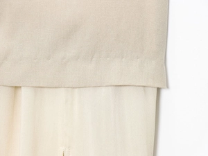 Gros plan détaillé du tissu de la jupe midi plissée beige avec coutures de qualité