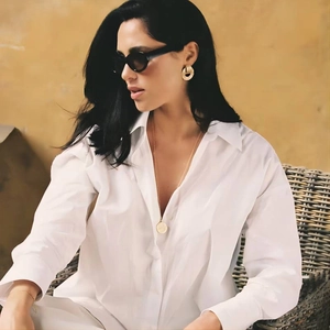 Hammered compass earrings and gold necklace styled with white shirt and sunglasses