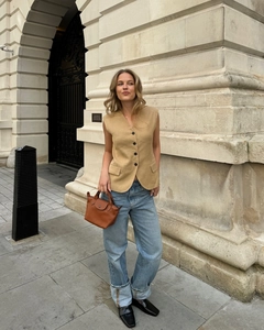 Outdoor-Streetstyle von khakifarbener Leinenweste und blauen Jeans mit Accessoires
