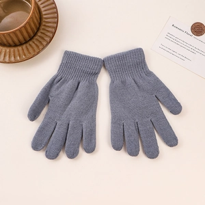 Flat lay of warm grey knit gloves with ribbed cuffs on a neutral beige background