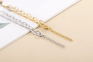 Detail of layered gold and silver snake chains with baroque shell pearl accents