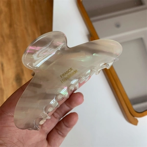 Close-up of translucent hair claw clip with France Handmade lettering and rainbow gloss