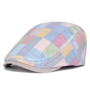 Detail of colorful patchwork plaid flat cap showing cotton texture and striped brim