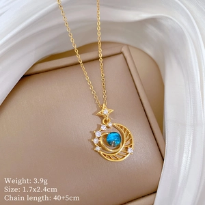 Detail of star and moon necklace with blue gemstone and diamonds on jewelry box