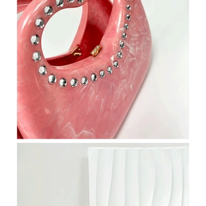 Detailed macro view of pink marble resin bag featuring rhinestone trim and gold hinge