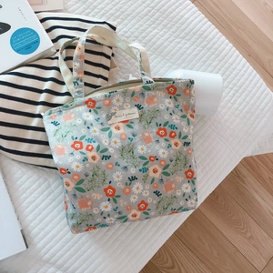 Floral cotton tote bag with zipper closure shown in a cozy home lifestyle setting