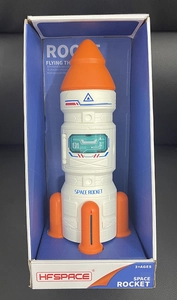 Detailed front view of white DIY space rocket toy with orange parts in retail packaging