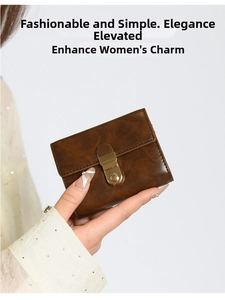 Close-up of vintage brown leather texture and elegant gold clasp on mini wallet