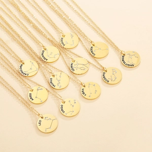 Golden titanium steel 12 Zodiac necklaces with sparkling crystals on beige background
