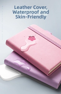 Close-up of pink and purple waterproof PU leather notebooks with elastic bands and water drops