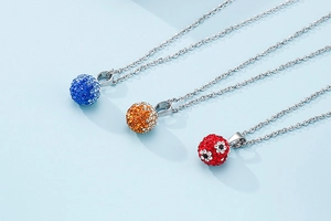 Detailed view of silver chain necklaces with colorful rhinestone crystal disco ball pendants