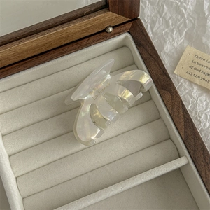 Detail of pearlescent white hair claw with gold La France text in a wooden jewelry box