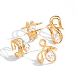 Four-piece set of gold-plated abstract rings with zircon stones on white background