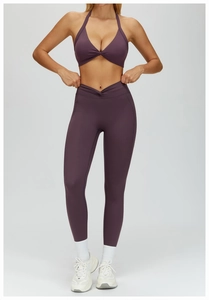 Detail of twisted halter sports bra and V-cross high waist yoga leggings in dark purple