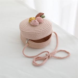 Detail of pink woven straw round bag for girls featuring handmade 3D fabric flower decorations