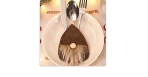 Brown gnome cutlery holder with plush beard on a white plate for Christmas dining decor