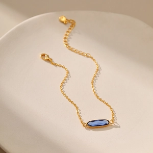 Bracciale minimalista placcato oro 18 carati con una gemma ovale in vetro blu scuro