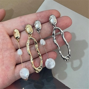 Detail of asymmetric baroque pearl earrings in gold and silver finish with S925 silver pins