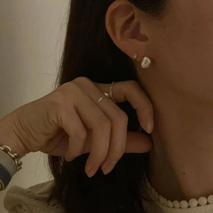Minimalist sterling silver jewelry set featuring croissant stud earrings and ring on model