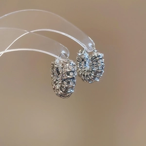 Macro view of silver U-shaped hoop earrings with diamond-encrusted multi-layer coils