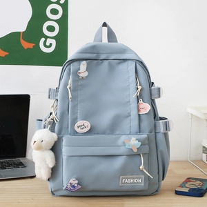 Light blue high-capacity school backpack with cartoon pins and cute plush bear charm