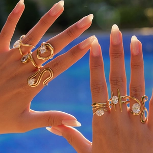 Detail of gold zircon rings on hands by the pool showing high-end craftmanship