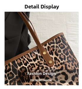 Close-up of leopard print tote bag with brown leather handles and gold rivet details
