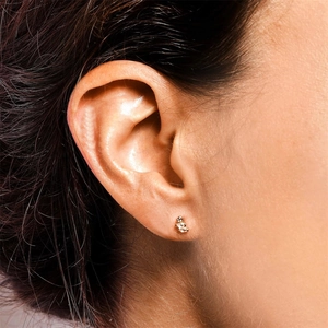 Close-up of a model wearing a S925 silver screw back earring with a diamond and opal accent