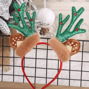 Close-up of reindeer antler headband with green glitter, bells, and ears on a display