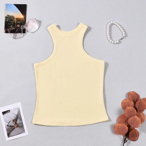 Flat lay of ribbed halter neck knit top in light yellow with summer fashion accessories