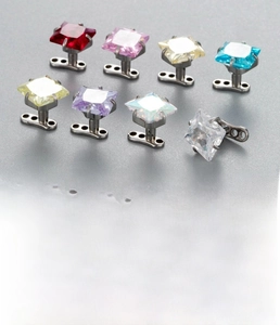 Detail view of 6mm square zircon dermal anchors in various colors with steel base