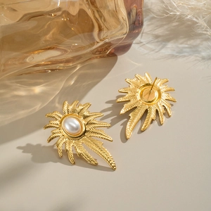 Elegant gold palm leaf stud earrings with white pearl detail for a summer vacation look